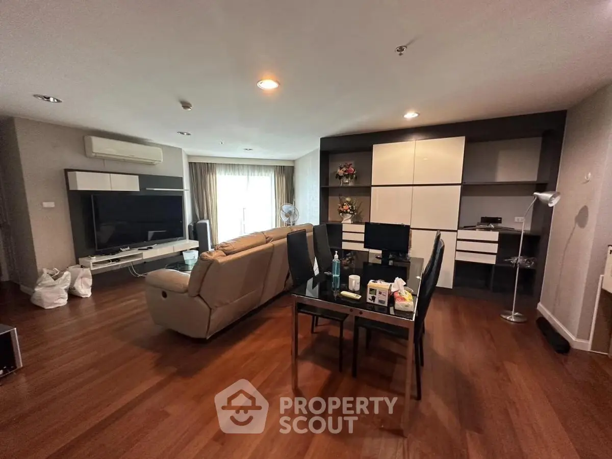 Spacious living room with modern furniture and wooden flooring, ideal for comfortable living.