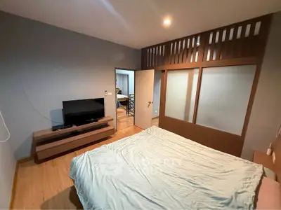 Spacious bedroom with modern decor and TV setup