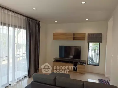 Modern living room with sleek TV setup and stylish curtains.