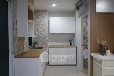 Modern kitchen with sleek white cabinets and geometric backsplash