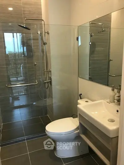 Modern bathroom with glass shower and sleek fixtures in a contemporary apartment.