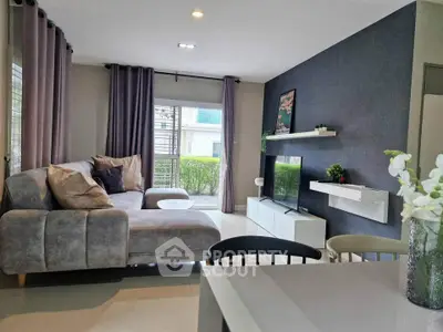 Modern living room with stylish decor and large windows offering natural light.