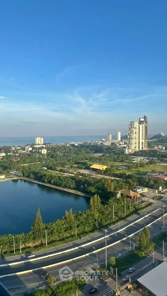 Stunning cityscape view with lush greenery and high-rise buildings near a serene water body.
