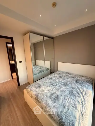 Modern bedroom with mirrored wardrobe and cozy bedding