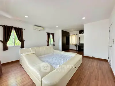 Spacious bedroom with elegant wooden flooring and modern furnishings