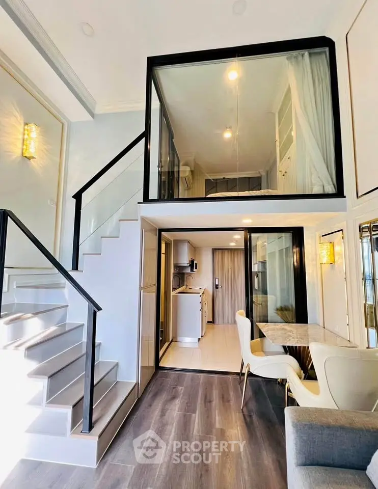 Modern duplex apartment with stylish interior and open layout, featuring a mezzanine bedroom and elegant staircase.