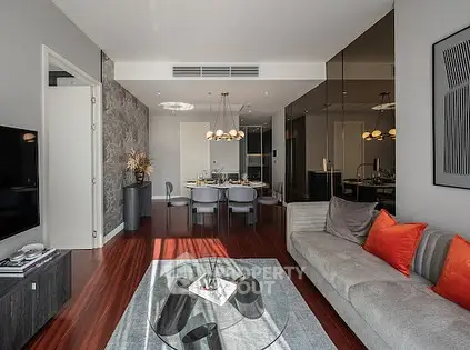 Modern living room with elegant decor and dining area, featuring hardwood floors and stylish furniture.