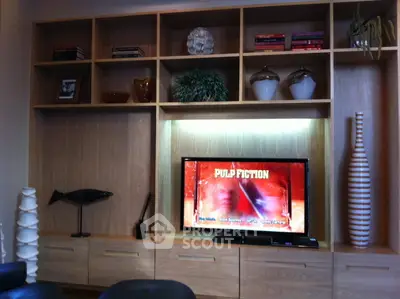 Stylish living room with built-in wooden shelves and modern decor featuring a TV.