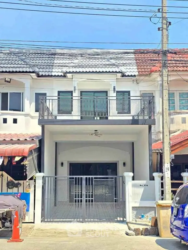 Charming townhouse with modern facade and gated entrance in a vibrant neighborhood.