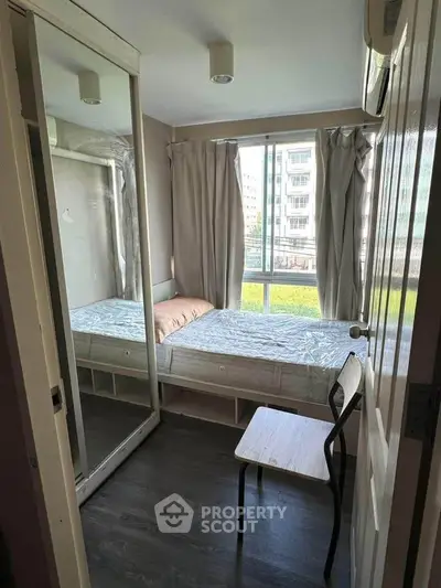 Cozy bedroom with mirrored wardrobe and large window view