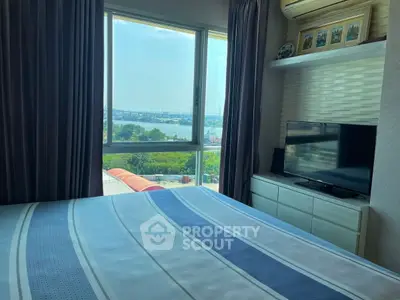 Cozy bedroom with scenic view, modern furnishings, and ample natural light.