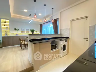 Modern open-layout kitchen with built-in appliances and stylish lighting in a cozy apartment.