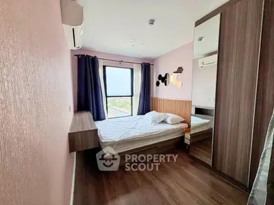 Modern bedroom with stylish decor and large window offering scenic views.