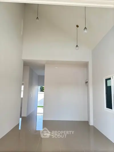 Spacious modern interior with high ceilings and elegant lighting fixtures.