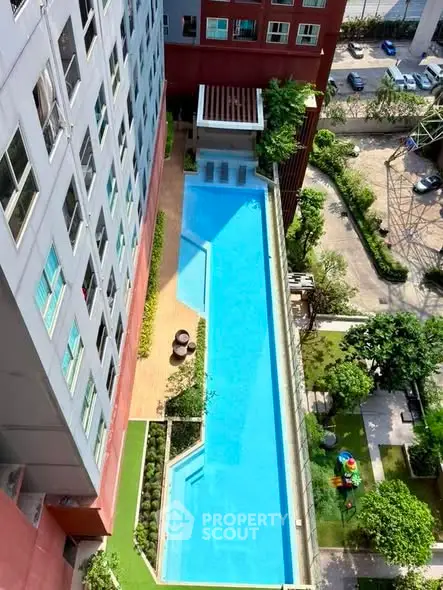 Stunning aerial view of modern apartment building with luxurious outdoor pool and landscaped garden.