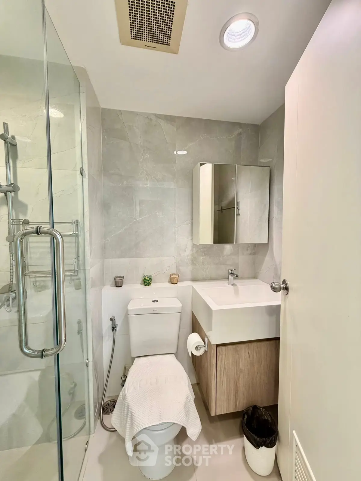 Modern bathroom with glass shower, sleek vanity, and neutral tiles