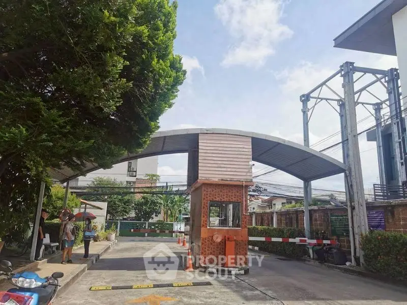 Secure gated entrance with modern design and lush greenery