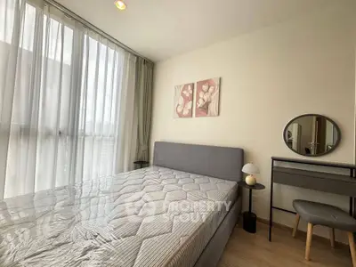 Modern bedroom with large window, stylish decor, and cozy furnishings in a bright apartment.