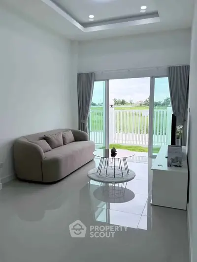 Modern living room with elegant sofa and stunning lake view through large glass doors.