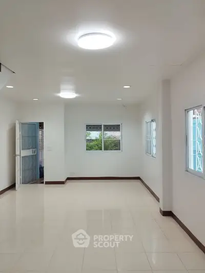 Spacious unfurnished room with bright lighting and tiled flooring, ideal for customization.