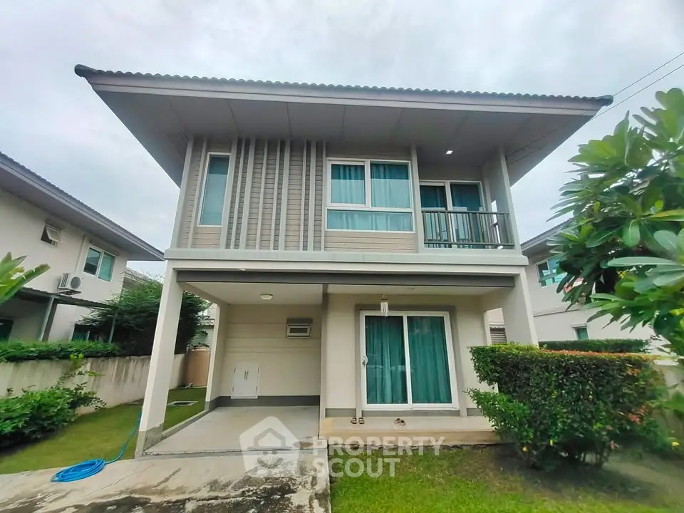 Modern two-story house with lush garden and covered parking in a serene neighborhood.