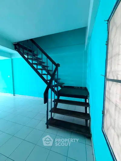 Spacious interior with modern staircase and vibrant blue walls, perfect for creative design opportunities.