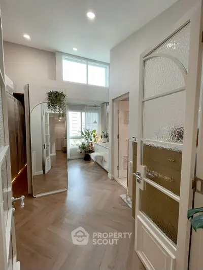 Chic and spacious bedroom with elegant wooden flooring and abundant natural light.