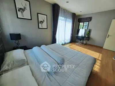 Spacious bedroom with modern decor and large window for natural light