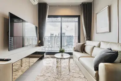 Modern living room with city view, sleek furniture, and large TV, perfect for urban living.