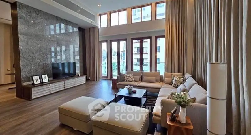 Luxurious living room with high ceilings and large windows offering stunning views.
