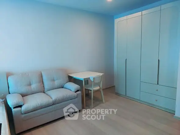 Cozy living room with modern sofa and sleek wardrobe, perfect for urban living.