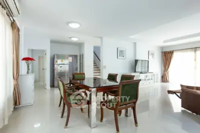 Spacious and elegant living room with dining area, modern furniture, and natural light.
