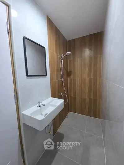 Modern bathroom with sleek design featuring a wall-mounted sink and shower area.