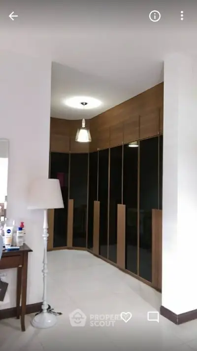 Spacious modern bedroom with sleek built-in wardrobes and elegant lighting