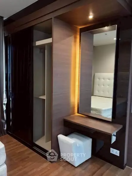 Modern bedroom with built-in wardrobe and vanity, featuring sleek design and ambient lighting.