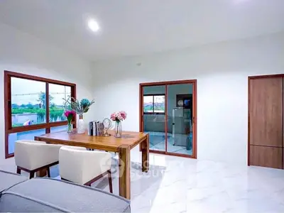 Spacious dining area with modern decor and large windows offering scenic views.