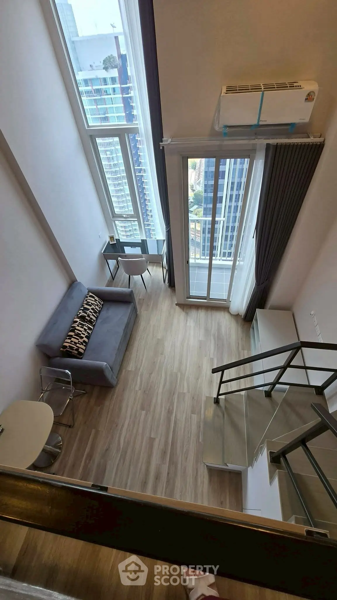Modern loft apartment with high ceilings and large windows offering stunning city views.