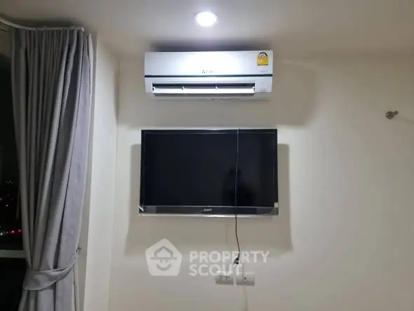 Modern living room with wall-mounted TV and air conditioning unit.