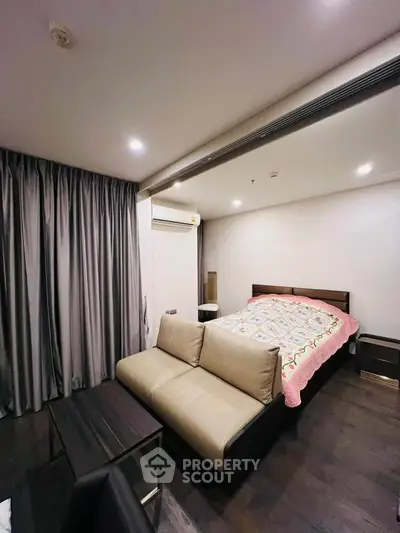 Modern bedroom with cozy sofa and stylish decor in a contemporary apartment.
