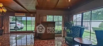 Luxurious living room with elegant decor and garden view, featuring marble flooring and plush seating.