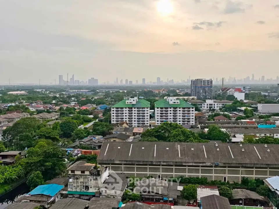 Stunning cityscape view from high-rise building with lush greenery and skyline in the distance.
