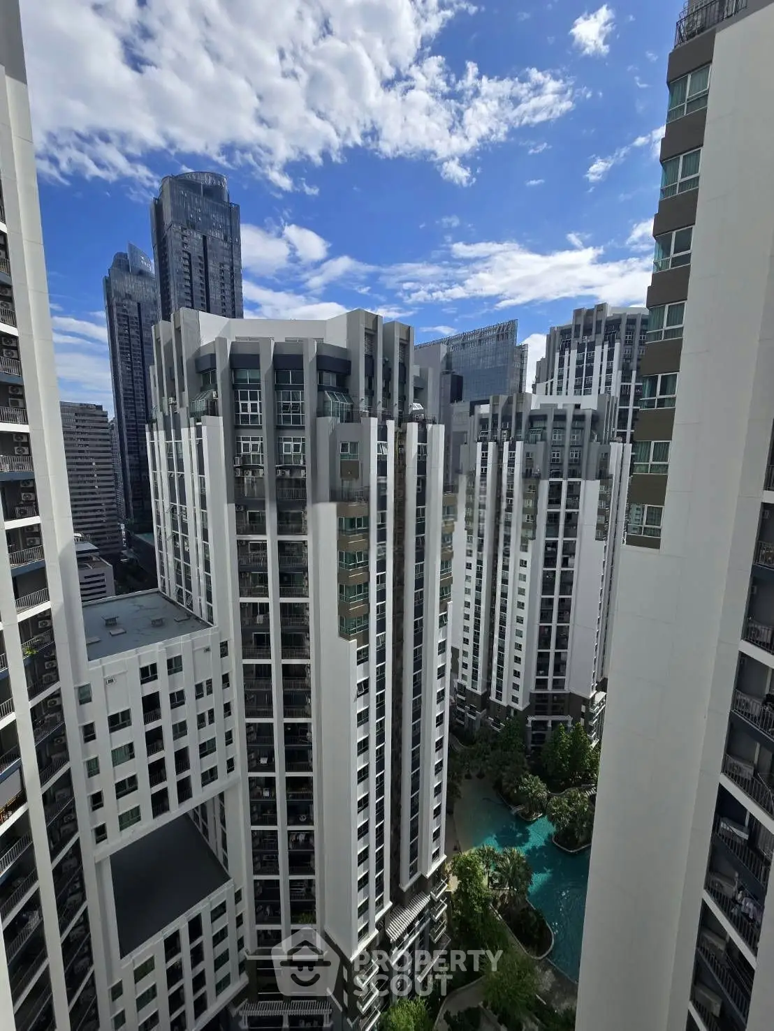 Stunning high-rise apartment buildings with a pool view in a vibrant urban setting.