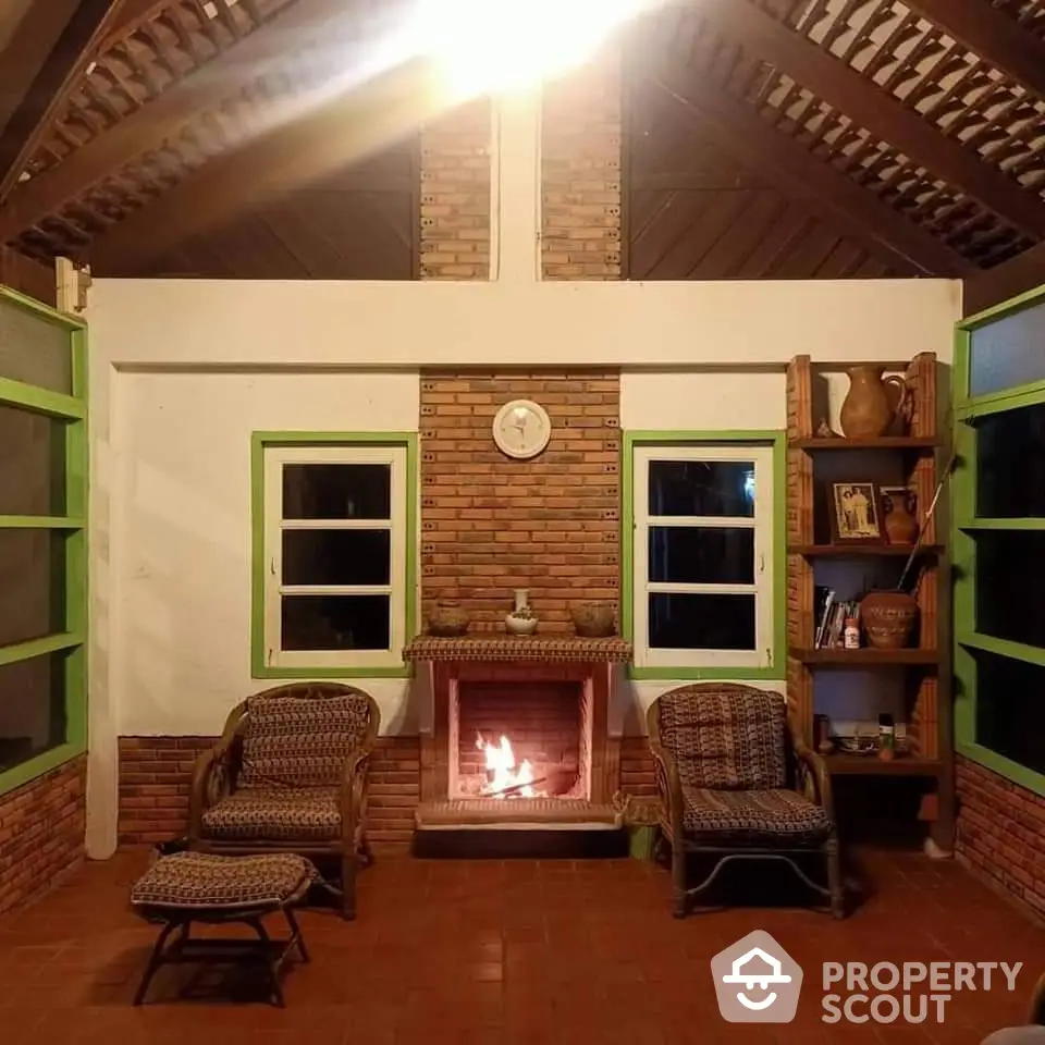 Cozy rustic living room with brick fireplace, high ceiling, and charming wicker furniture, perfect for relaxing evenings.