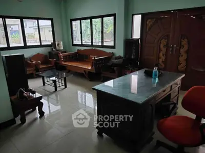 Spacious living room with wooden furniture and large windows for natural light.