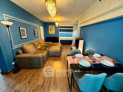 Spacious living room with elegant decor and dining area, featuring blue walls and stylish lighting.