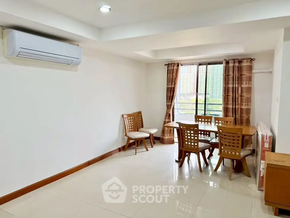 Spacious dining area with natural light and modern air conditioning unit.