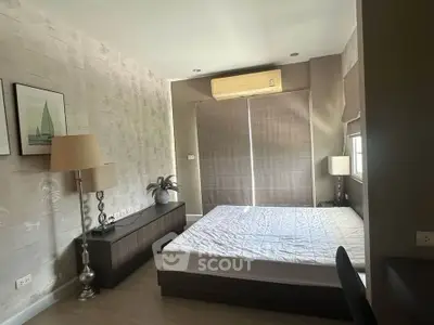 Modern bedroom with stylish decor and natural light, featuring a sleek bed and elegant furnishings.
