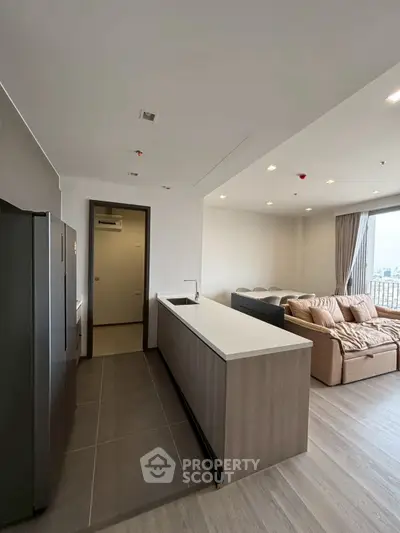 Modern open-layout kitchen and living room with sleek design and natural light