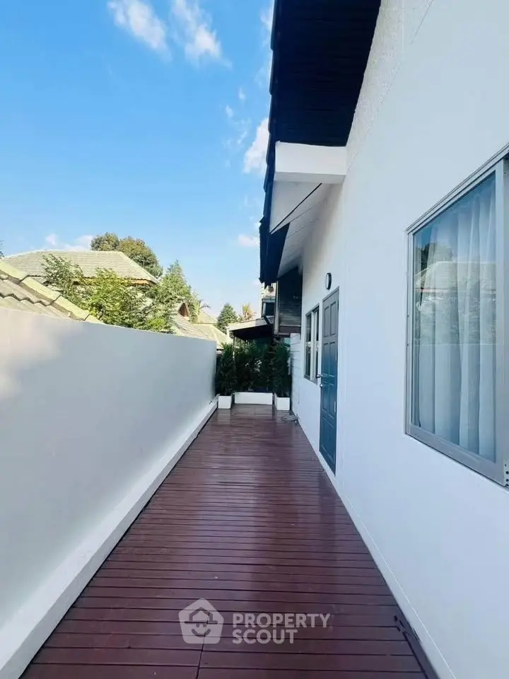 Charming exterior view of a modern home with wooden deck and lush greenery, perfect for relaxation.