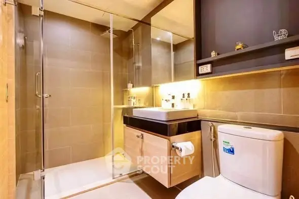 Modern bathroom with glass shower and sleek fixtures in luxury apartment.